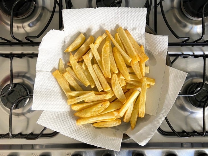 Um recipiente com batatas fritas no papel toalha.