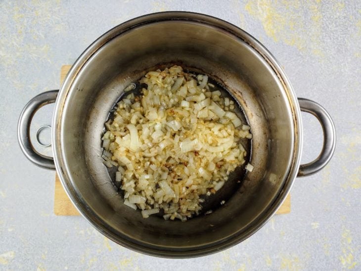Uma panela com o alho e cebola a dourar.