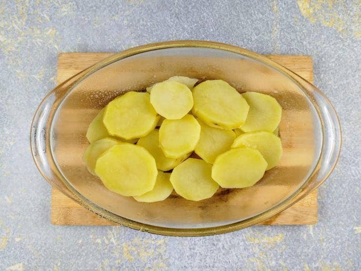 Uma travessa com a camada de batatas.