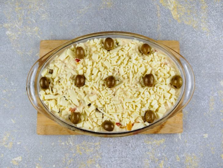 Travessa com a batata finalizada com queijo e azeitonas.