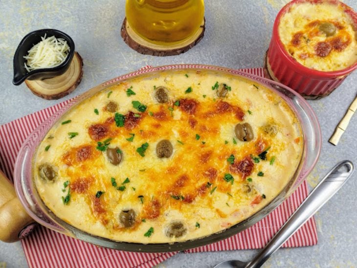 Travessa contendo batata gratinada com bacalhau após assar.