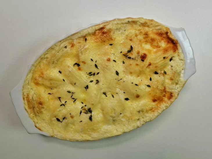 Um refratário com a batata gratinada com requeijão.