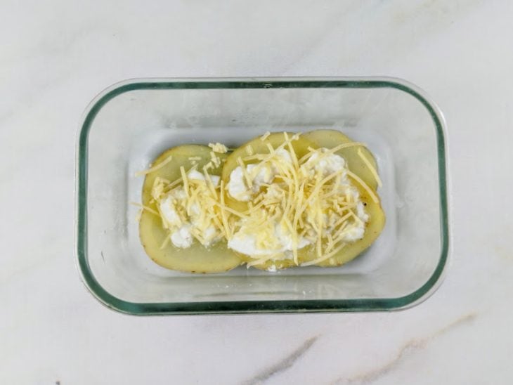 Iogurte natural e queijo parmesão adicionados ao refratário.