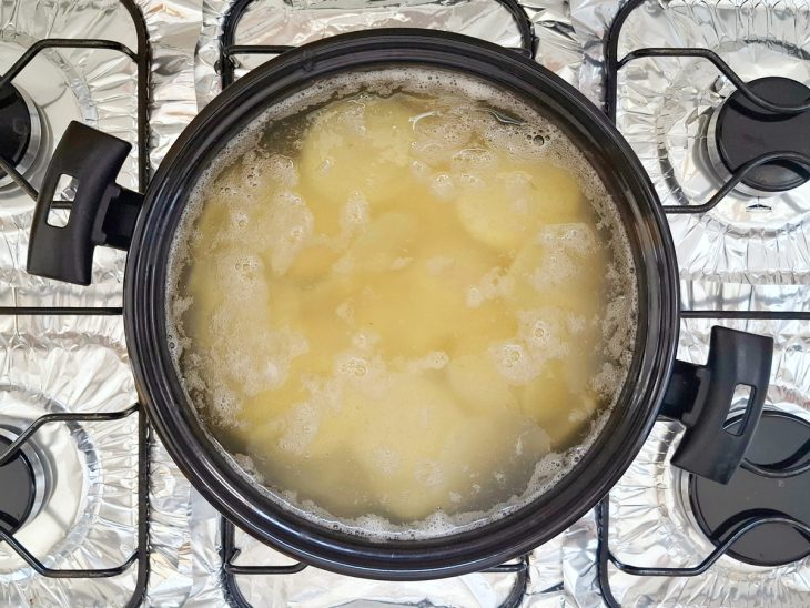 Batatas cozinhando em uma panela com água.
