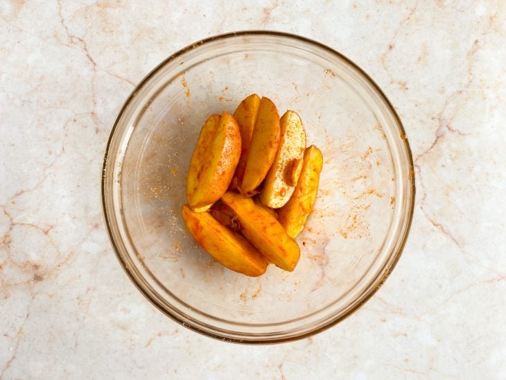 Tigela com batatas temperadas com alho, azeite, sal e paprica.