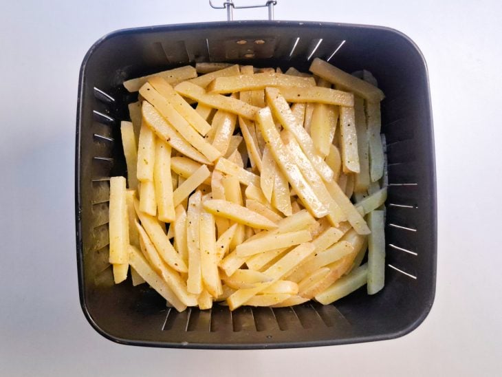 Batatas temperadas dentro da cestinha da air fryer.