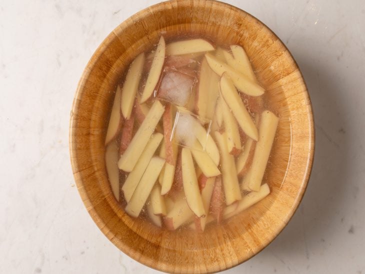 Batatas de molho na água com gelo.