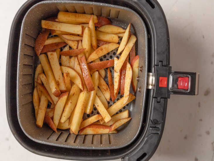 Batatas acomodadas no cesto da Air Fryer.