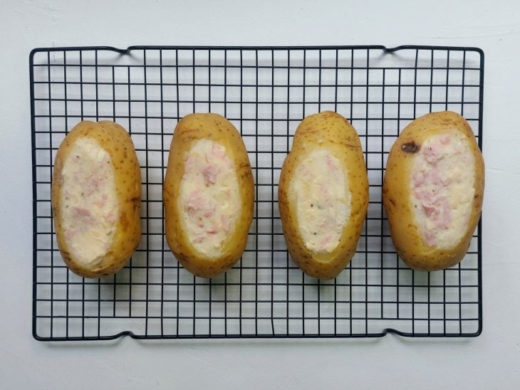 Uma grade com batatas recheadas.