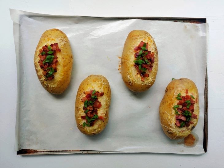 Uma assadeira com batatas recheadas após assar.