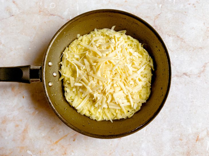 queijo meia cura espalhado por cima da batata ralada.