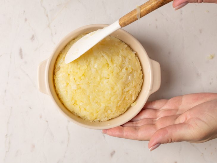 Batata ralada adicionada ao recipiente e nivelada.