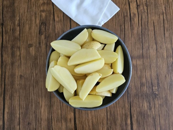 Um recipiente contendo batatas cortadas.