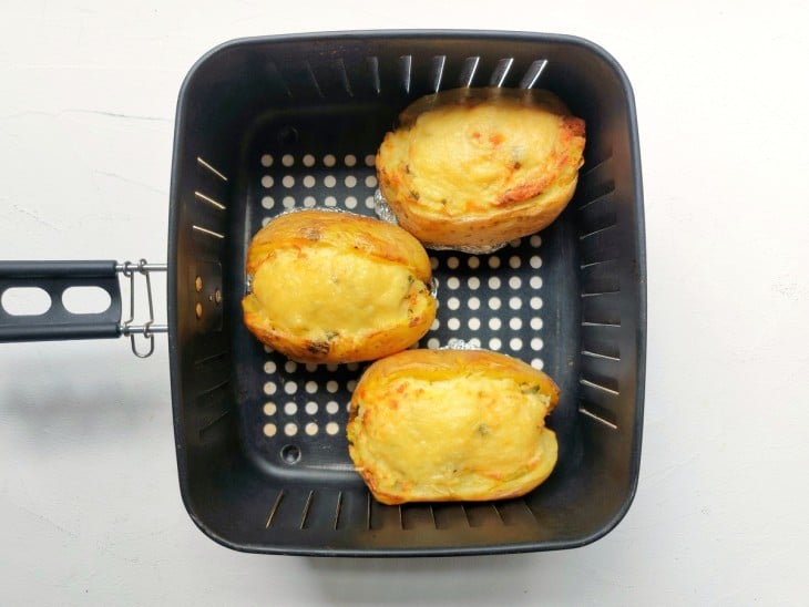 Batatas recheadas e assadas dentro da cesta da airfryer.