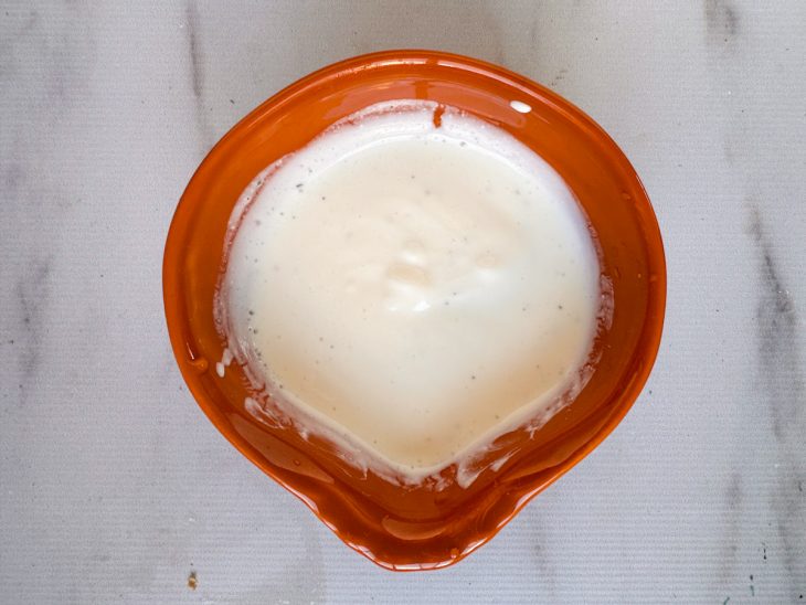 Sour cream sendo misturado com limão, sal, pimenta e raspas.