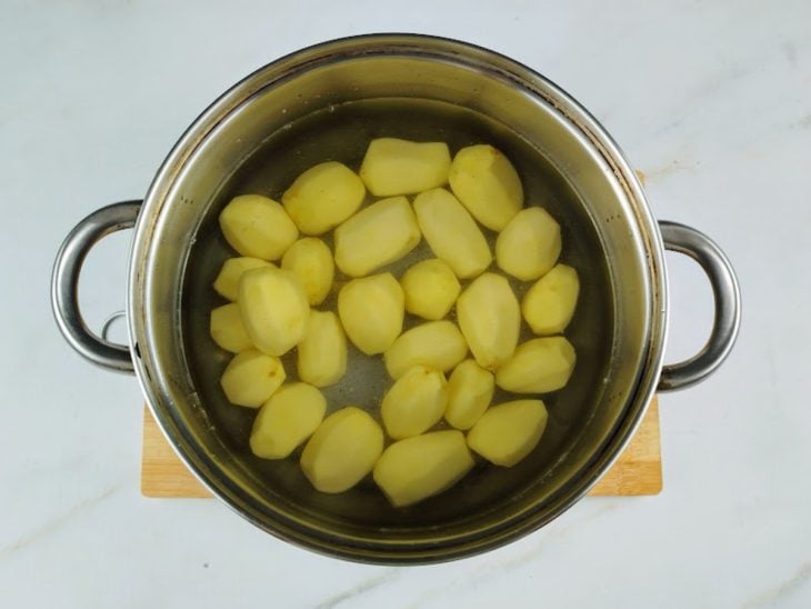 Uma panela com água e batatas.