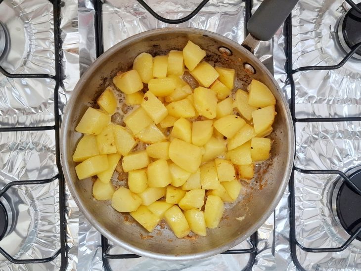 Panela com as batatas sendo salteadas.