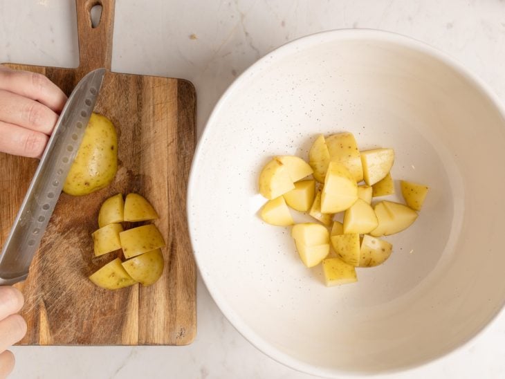 Uma tábua e um prato com a batata cortada.