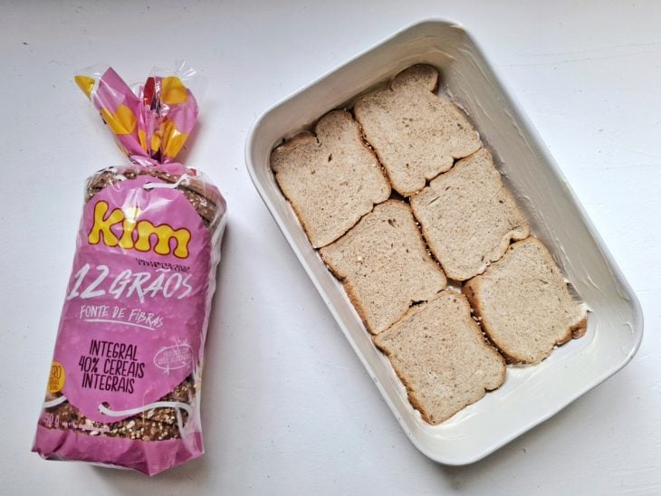 Uma camada de pão no fundo da forma untada.