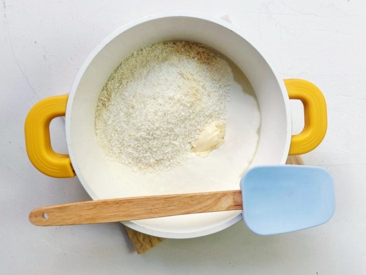 Uma panela com leite condensado, creme de leite, coco ralado e manteiga.