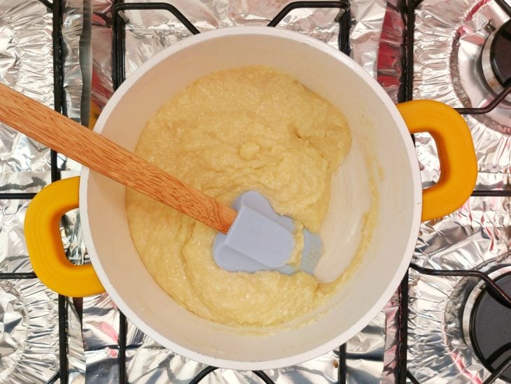 Uma panela com a mistura de leite condensado, creme de leite, coco ralado e manteiga ao ponto.
