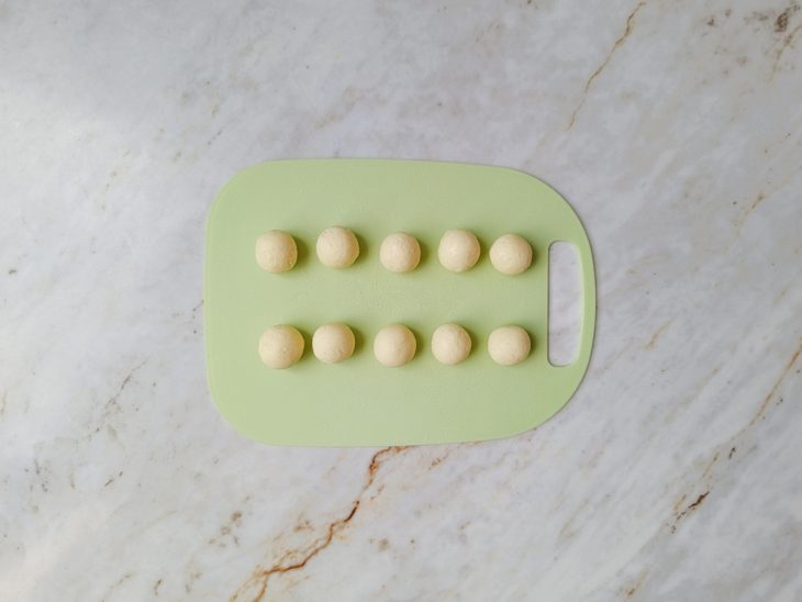 Bolinhas de beijinho dispostas na bandeja.