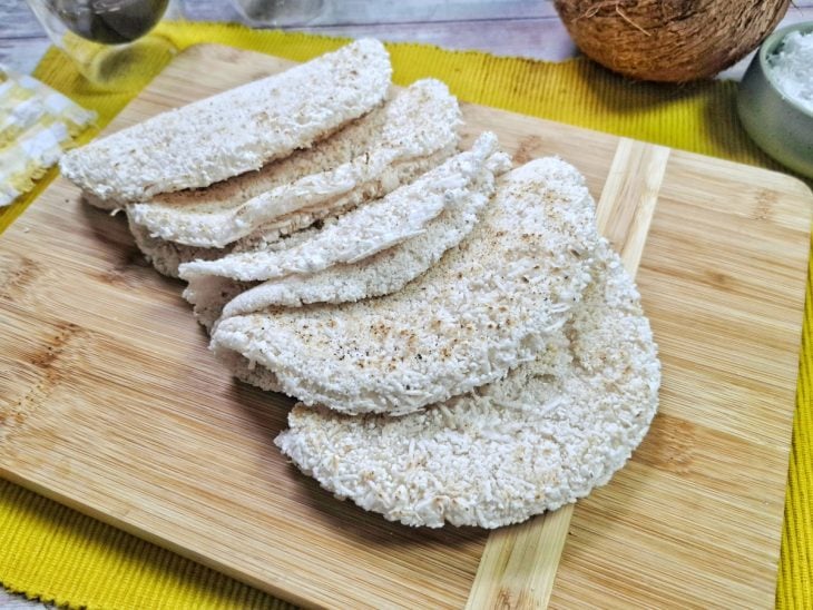 Beijus de coco prontos para consumo sobre uma tábua de madeira.