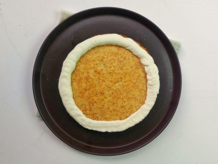 Um bolo com as boradas cobertas com chantininho.