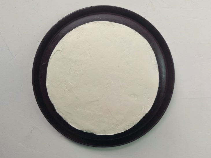 Um recipiente contendo um bolo coberto com chantilly.