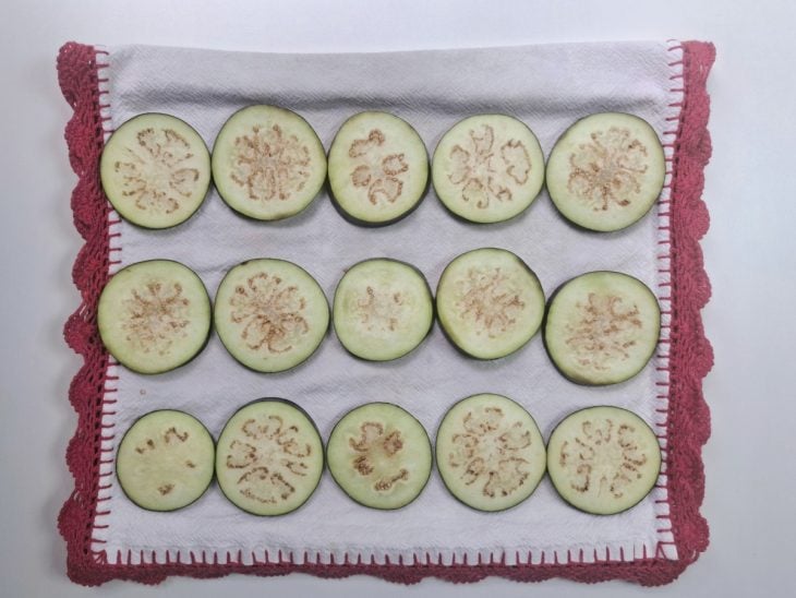 Rodelas de berinjela sobre um pano de prato.