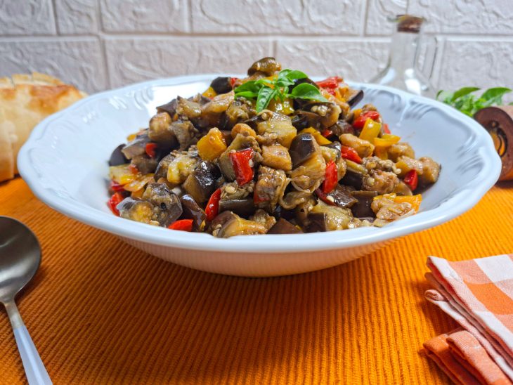 Berinjela no forno com azeite e pimentão servida num prato.