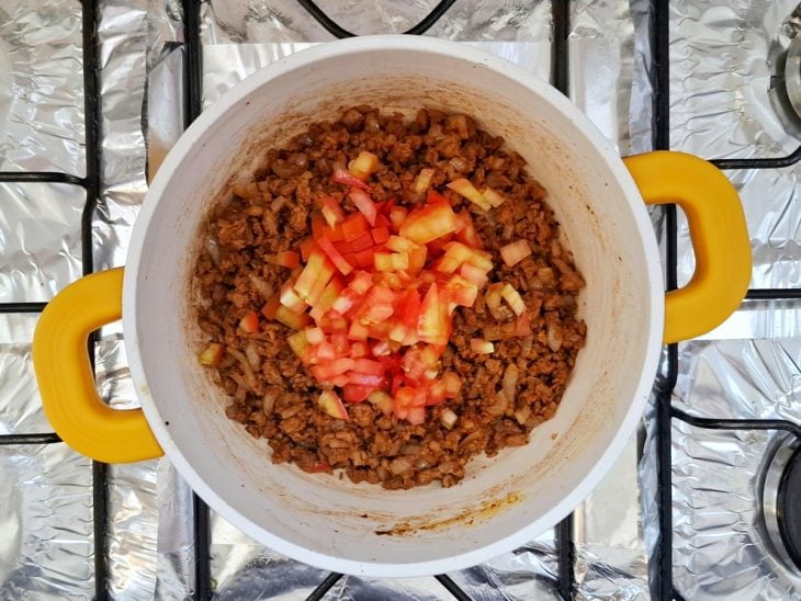 Proteína de soja com temperos e tomate picado refogando em uma panela.
