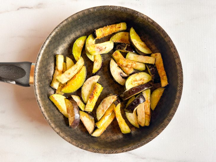 Na frigideira, a berinjela grelhando.