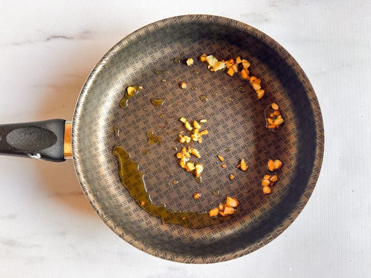 Na frigideira, o alho no azeite.