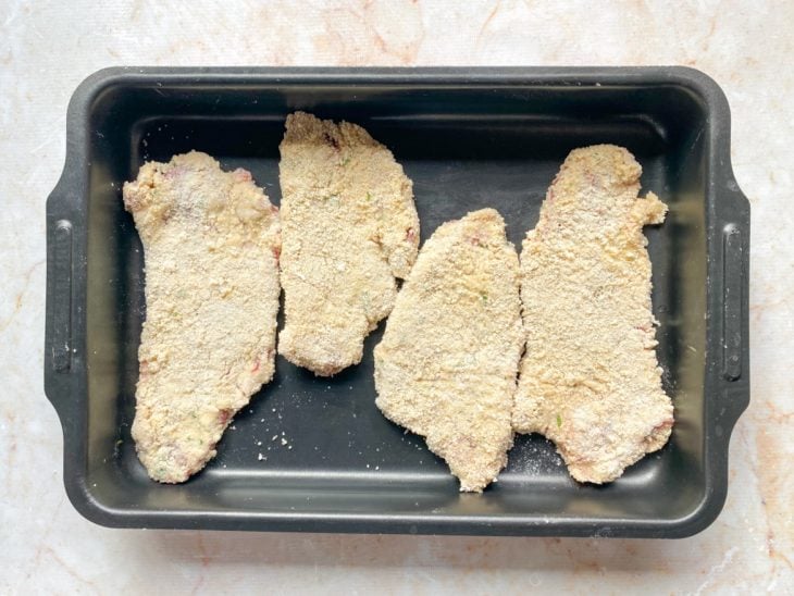 Uma forma com os bifes empanados.