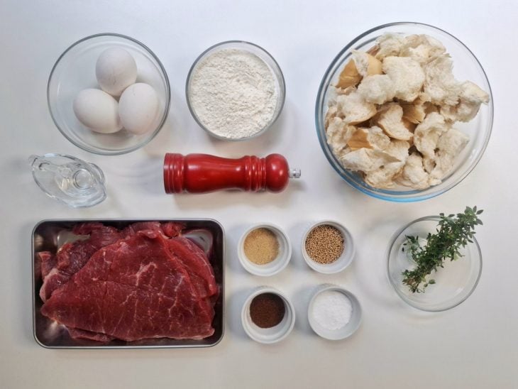 Ingredientes para a receita de bife à milanesa sem farinha de rosca separados em uma bancada.