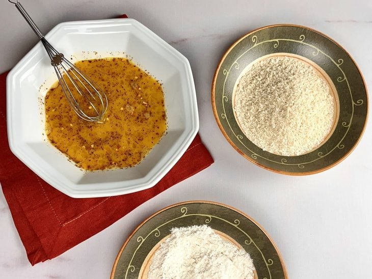 Recipiente contendo ovos batidos, farinha de trigo e farinha de rosca.