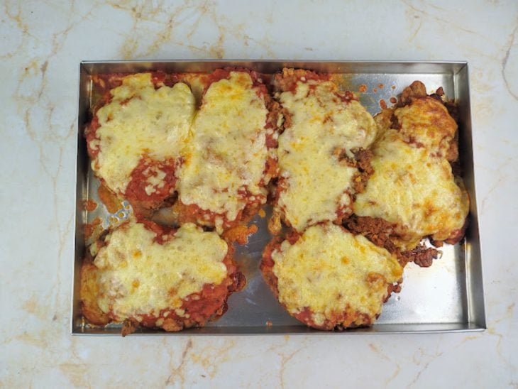 Bifes com queijo derretido após tempo de forno.