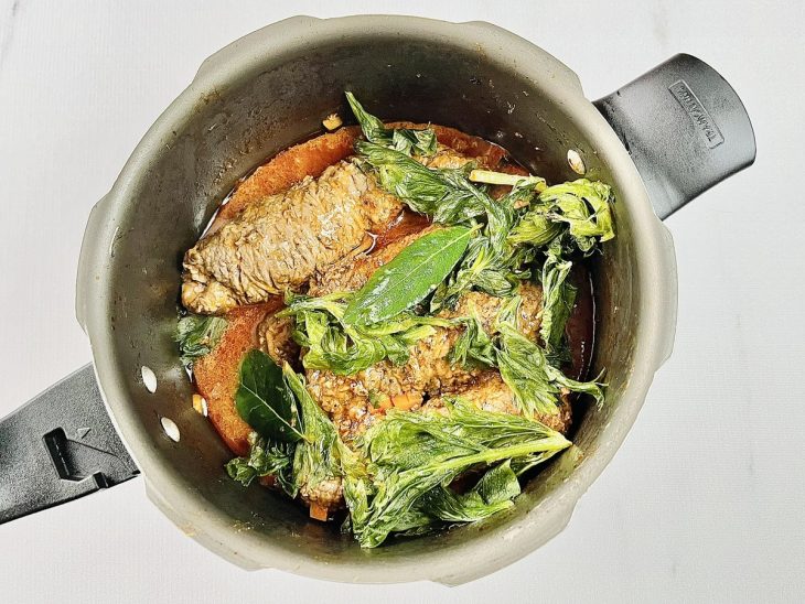 adição de temperos frescos e molho ao cozimento do bife a rolê.