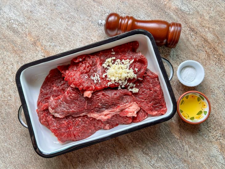bife temperado com alho para preparo na pressão.