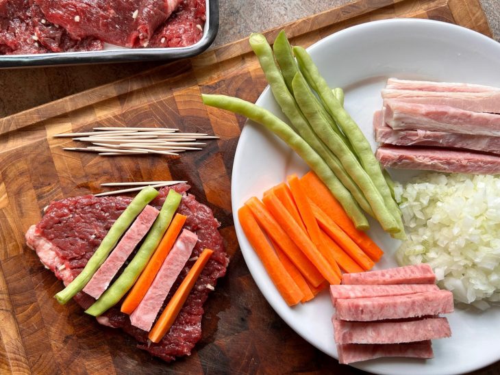 montagem dos bifes a rolê com vagem, cenoura, bacon e calabresa