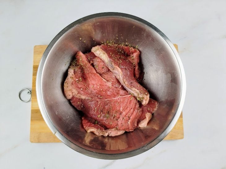 Uma tigela com os bifes temperados.