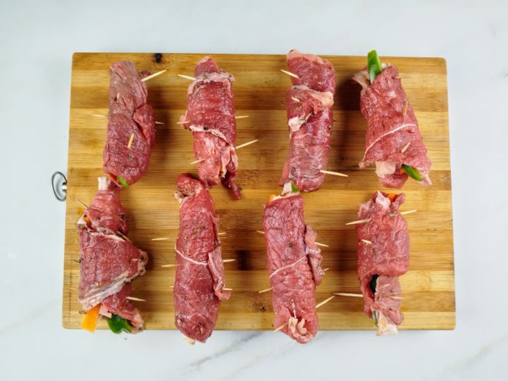 Uma tábua com os bifes temperados e recheados.
