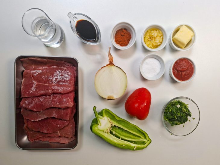 Ingredientes organizados na bancada com alho já amassado.