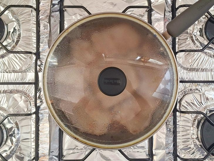 Bifes cozinhando tampados na própria água.