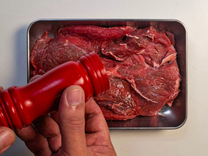 Carne sendo temperada.