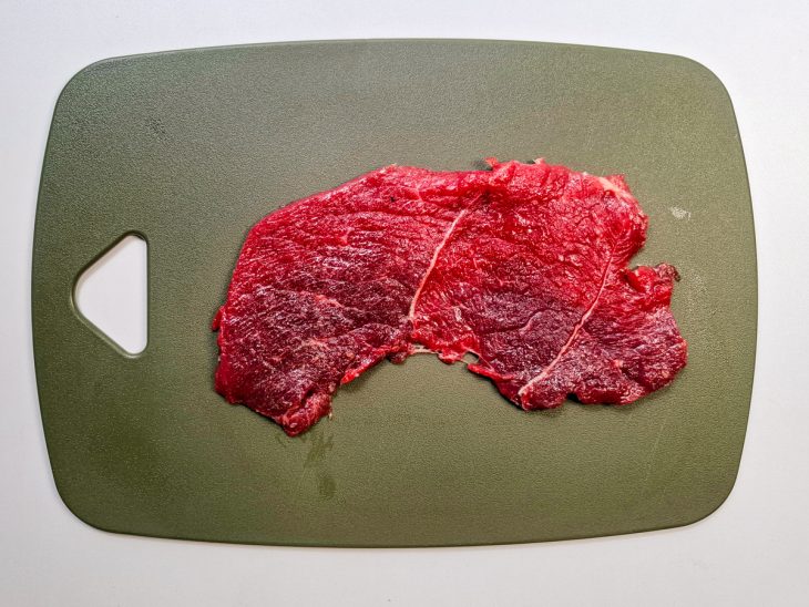 Numa tábua, o bife disposto.