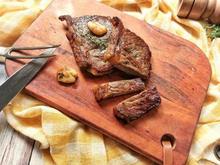 Bife de chorizo com algumas fatias cortadas em uma tábua.