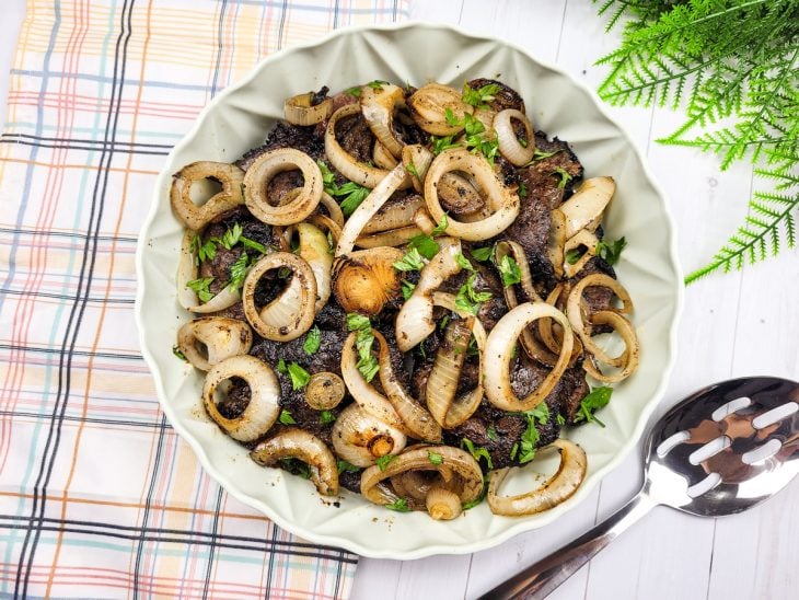 Refratário com bifes de fígado com cebolas em rodelas.