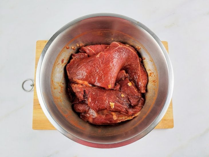 Bifes temperados na tigela de inox redonda.